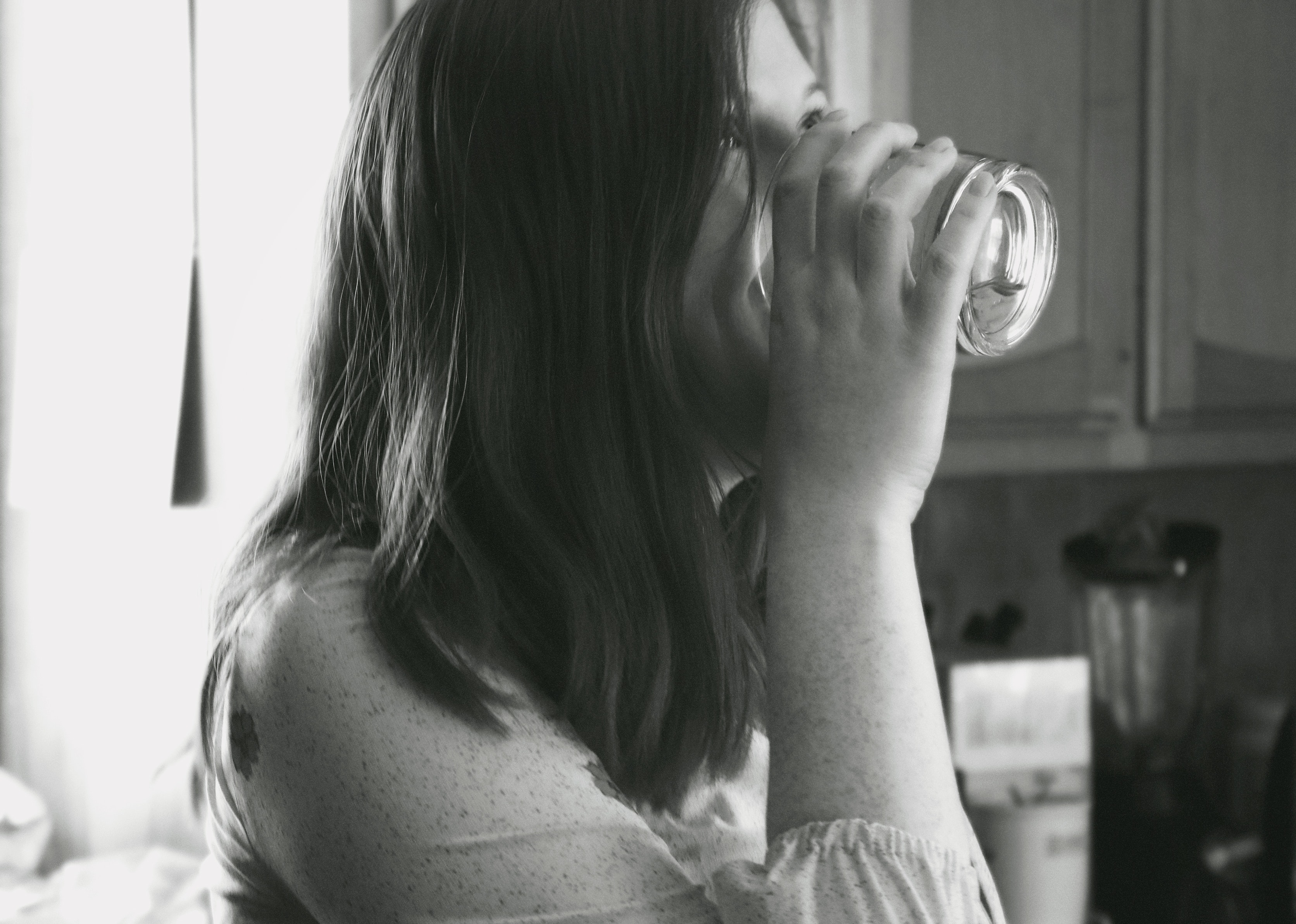 woman drinking from glass of water