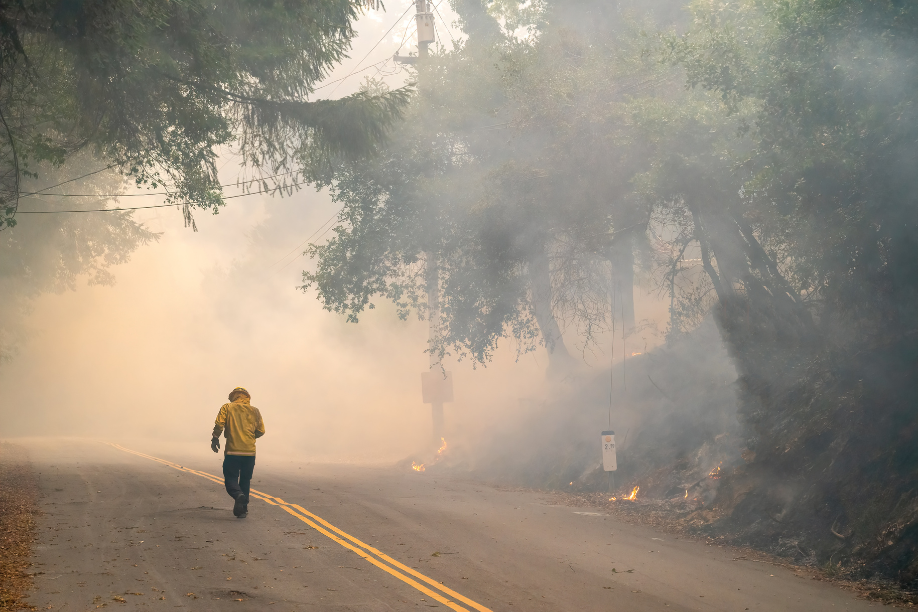 Firefighter walking into wildfire smoke